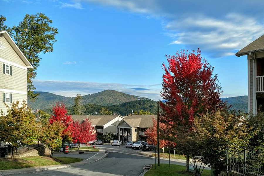 Apartment community with residential buildings, autumn trees, and mountain views near Boone, North Carolina.