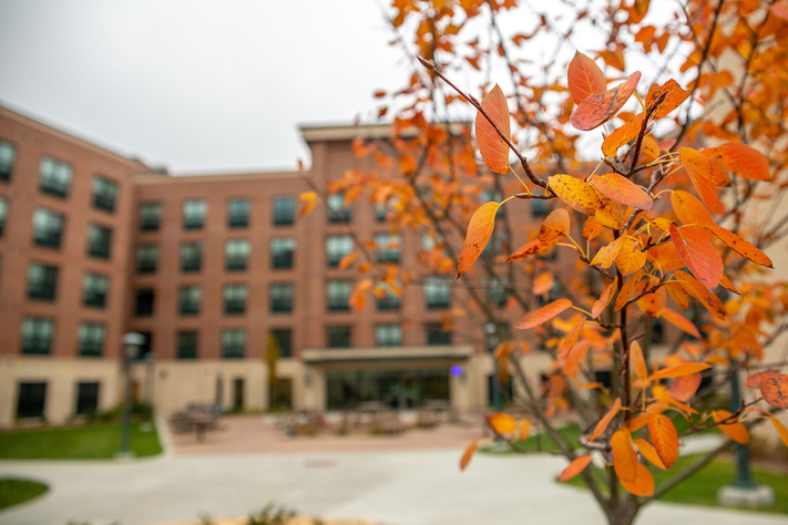 Orange autumn leaves frame a residence hall courtyard on App State's campus in the fall season.