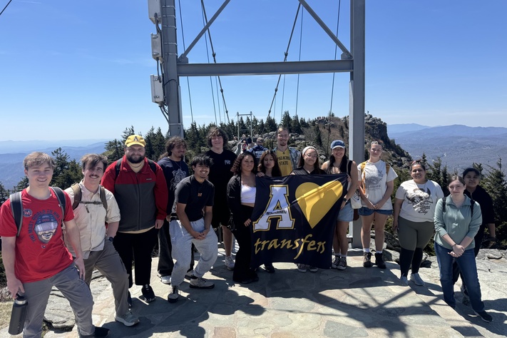 Transfer Residential Learning Community students gather at Grandfather Mountain with an App State banner.