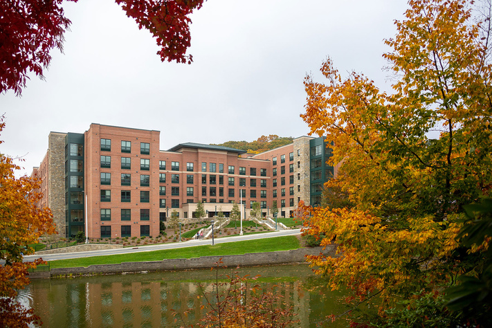 New River Hall viewed across Duck Pond and framed by colorful fall foliage at App State