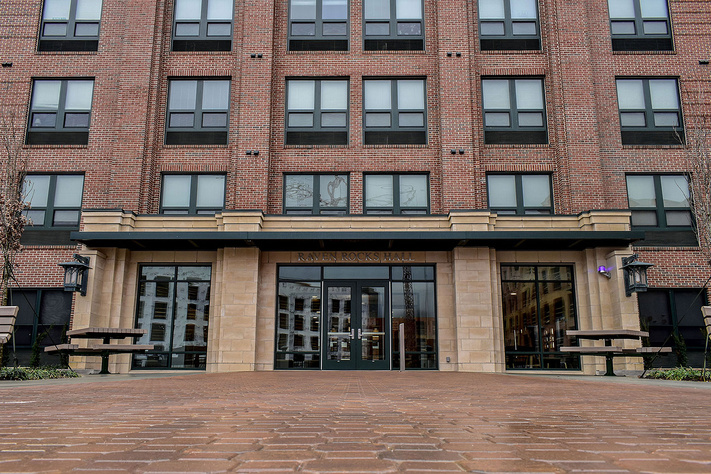 Main entrance to Raven Rocks Hall with brick exterior, covered entry and outdoor tables.