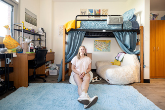 Furnished room directly illustrates what students may bring—bedding, storage, décor and other essentials