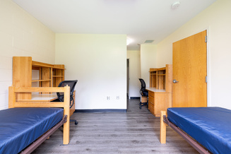 Furnished shared bedroom at Appalachian Heights with two beds, desks, chairs and shelving