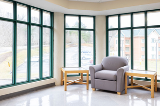 Appalachian Heights study nook with an armchair, side tables and floor-to-ceiling windows.