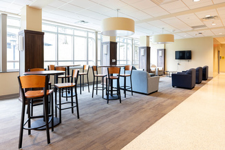 Spacious Belk Hall lobby with high-top tables, lounge seating and floor-to-ceiling windows
