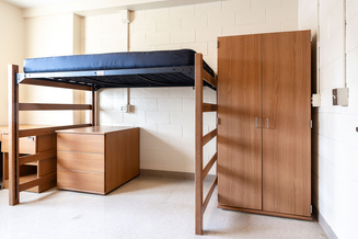 Furnished Cone Hall bedroom with lofted beds, storage chests, shelving and wardrobes