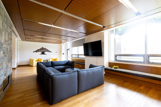 Summit Hall fireside lounge with sectional sofas, television, window seating and fireplace.