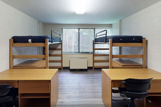 White Hall double room with two raised beds, individual desks, chairs and a large window.