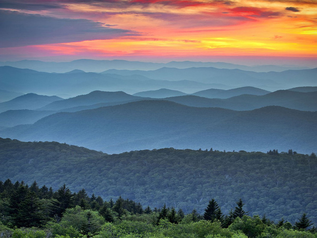 Sunset over the Blue Ridge Mountains, with colorful skies and layered mountain ridges stretching into the distance.